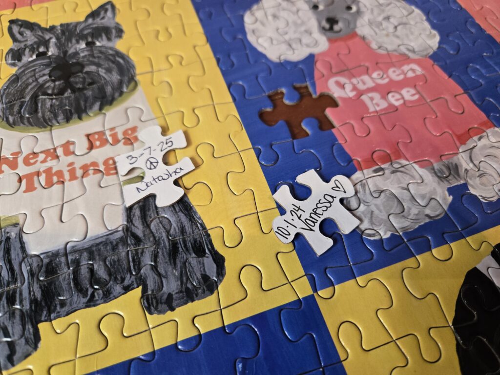 A finished 500 piece Galison dog puzzle with two signed pieces