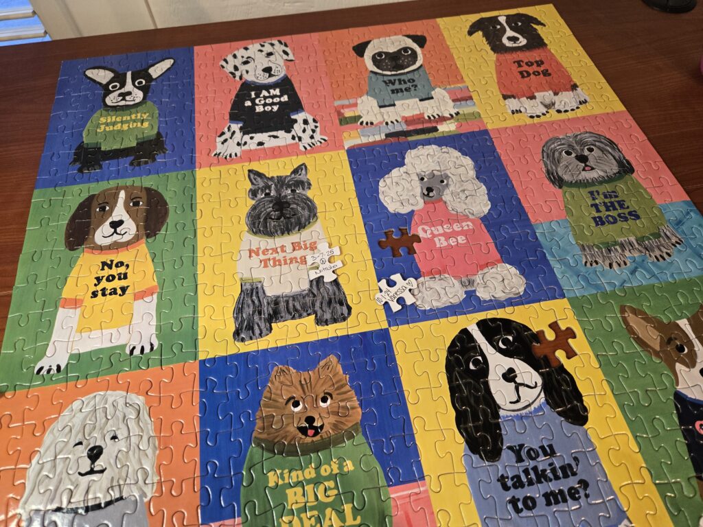 A finished 500 piece Galison dog puzzle with two signed pieces